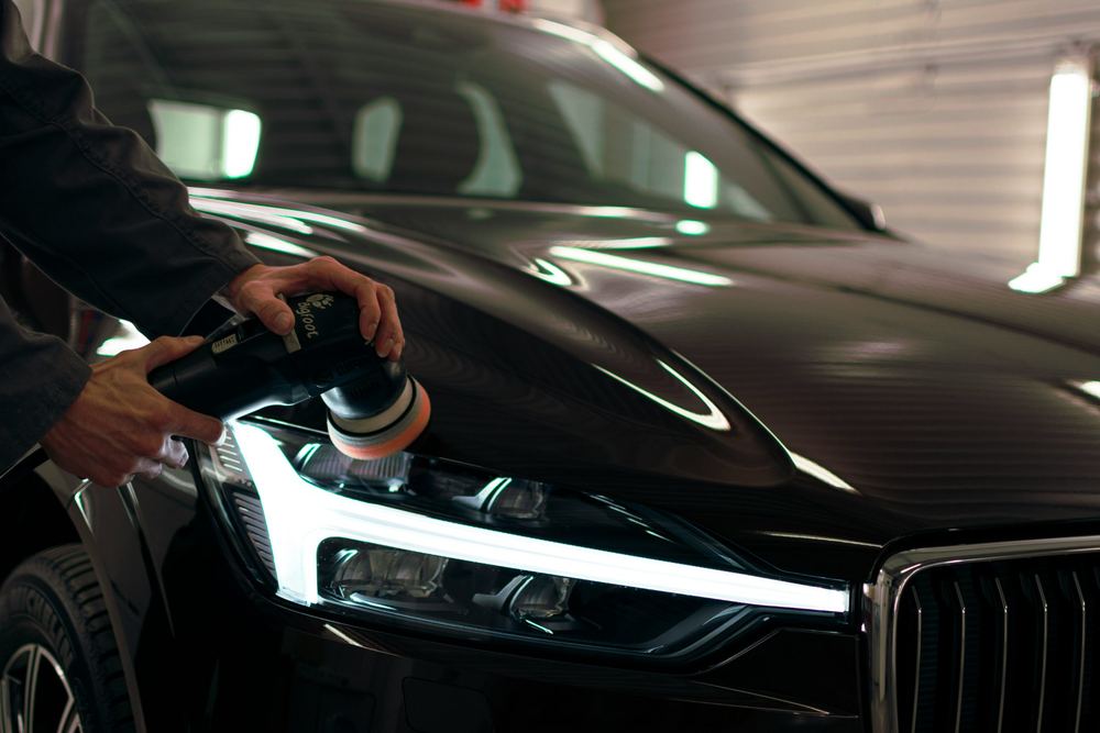 Polissage d'une voiture noire avant la vente